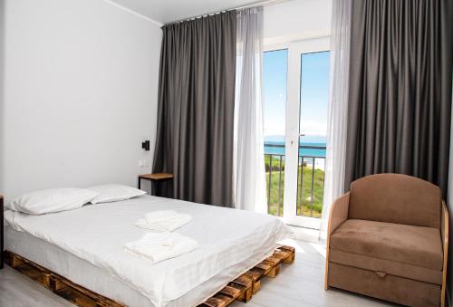 ein Schlafzimmer mit einem Bett, einem Stuhl und einem Fenster in der Unterkunft Silence hotel in Tscholponata