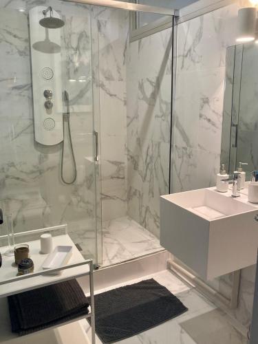 une salle de bain blanche avec une douche et un lavabo dans l'établissement Appartement style Loft quartier Saint-Augustin Bordeaux, à Bordeaux