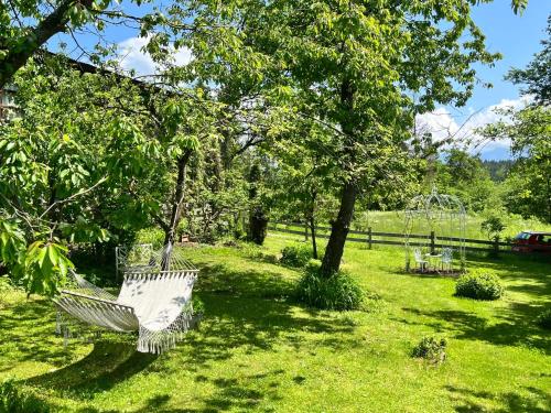 a hammock in a yard with trees and a playground at Chalet Reserl by Interhome in Lichtpold