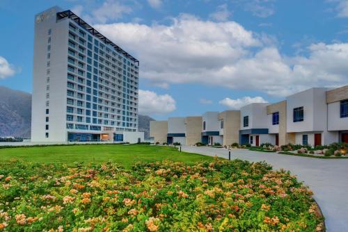 a building with a field of flowers in front of a building at Royal M Al Aqah Beach Resort by Gewan in Al Aqah