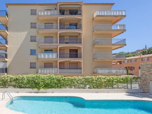 un immeuble avec une piscine devant un immeuble dans l'établissement Studio La Palmeraie II-3 by Interhome, à Sainte-Maxime