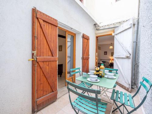 Apartment Rue de la Pompe by Interhome في أنتيب: طاولة خضراء وكراسي في غرفة مع باب