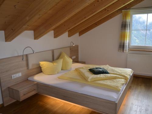 カップルにあるHoliday Home Bergblick - KPL118 by Interhomeのベッドルーム1室(大型ベッド1台、黄色い枕付)