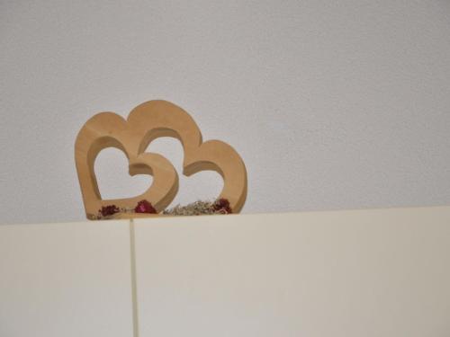 a wooden sculpture of two hearts on top of a white shelf at Holiday Home Bergblick by Interhome in Kappl