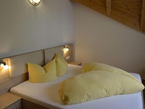 a bedroom with two yellow pillows on a bed at Holiday Home Bergblick by Interhome in Kappl