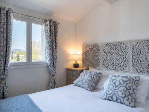 une chambre avec un lit blanc et une fenêtre dans l'établissement Apartment Grand Bassin by Interhome, à Grimaud