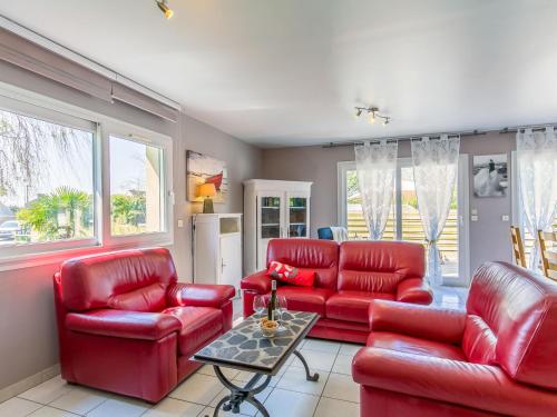 a living room with red leather furniture and windows at Holiday Home Ker Jean by Interhome in Plouescat
