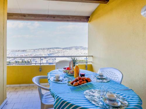 a table with a blue and white table cloth with fruit on it at Apartment Port Saint Michel by Interhome in Cap d'Agde