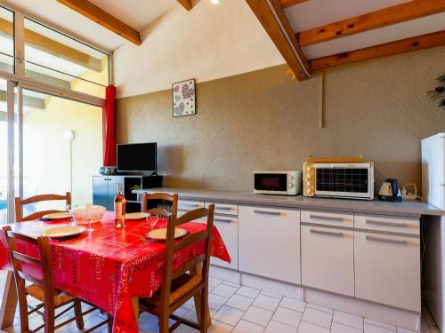 a kitchen with a table with a red table cloth at Apartment Port Saint Michel by Interhome in Cap d'Agde