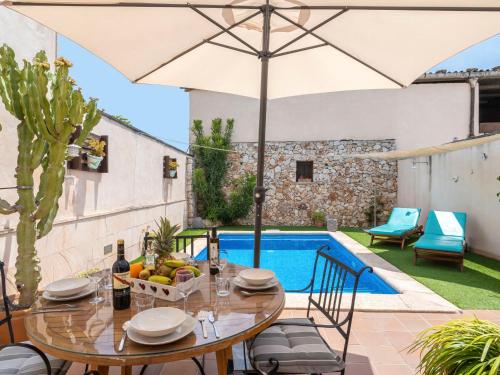a patio with a table with an umbrella and a pool at Holiday Home Pueblo - PSR175 by Interhome in Porreres