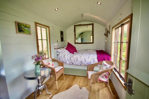 um quarto com uma cama, uma mesa e cadeiras em Bluebell huts em Abergavenny
