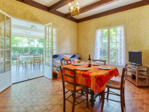 un comedor con mesa y sillas y un dormitorio en Holiday Home La Côte d'Argent - MVT175 by Interhome, en Montalivet-les-Bains