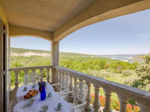 a table and chairs on a balcony with a view at Apartment Bauduen by Interhome in Bauduen