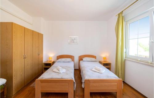 2 camas individuales en una habitación con ventana en Pet Friendly Home In Skabrnja With Kitchen, en Galovac