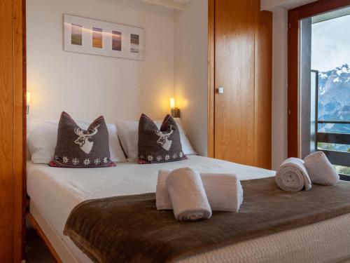 1 dormitorio con cama con almohadas y ventana en Apartment Christiania I G8 by Interhome en Nendaz