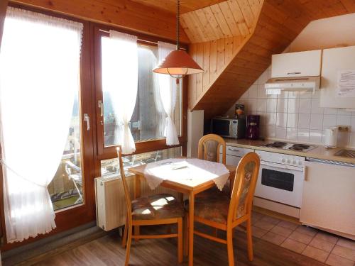 cocina con mesa y sillas y cocina con fogones en Apartment Schwarzwaldblick-8 by Interhome, en Schonach