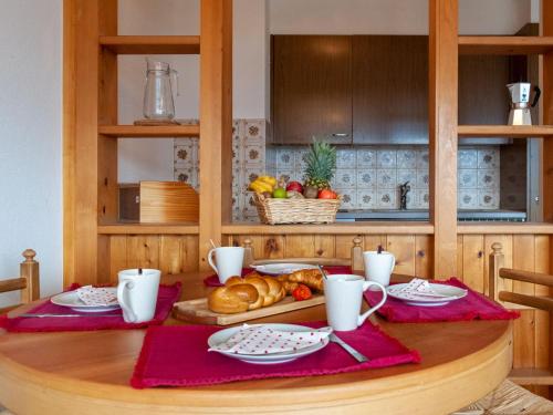 una mesa con un plato de pan y una cesta de fruta en Apartment Christiania I G8 by Interhome en Nendaz