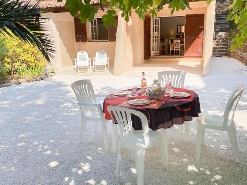 a table with white chairs and a red table cloth at Apartment Les Mas de Gigaro by Interhome in La Croix-Valmer