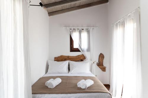 a bedroom with a bed with two towels on it at Tethys by Cretan Pnoe Adults Only in Chania