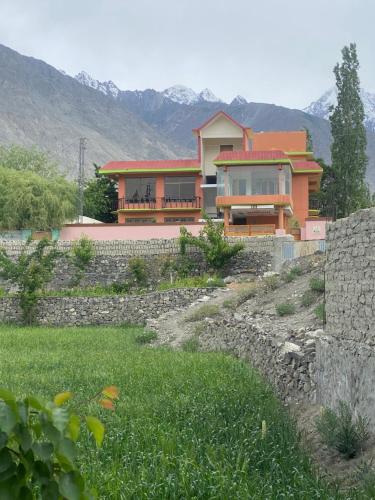 a house on a hill with mountains in the background at Kamals Lodge in Skardu