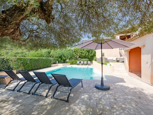 un grupo de sillas y una sombrilla junto a una piscina en Villa Le Petit Rouveau by Interhome, en Guerre Vieille