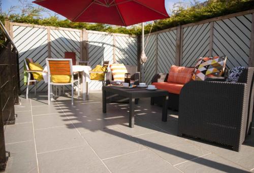 a patio with chairs and a table with an umbrella at Dunagree Bed & Breakfast in Greencastle