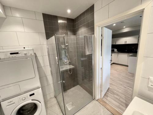 a bathroom with a shower and a washing machine at Apartment Lilletveitvegen in Bergen