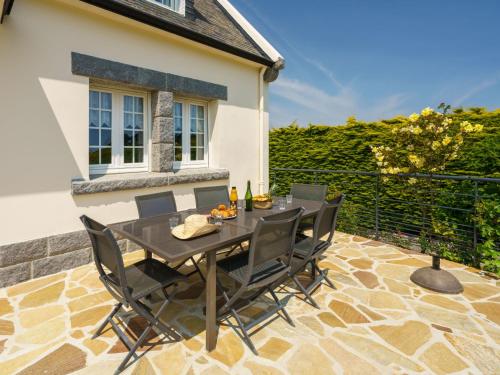 une terrasse en pierre avec une table et des chaises. dans l'établissement Holiday Home Ty Didrouz by Interhome, à Plobannalec