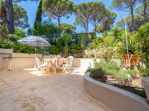 un patio avec une table, des chaises et un parasol dans l'établissement Holiday Home Domaine des Restanques by Interhome, à Sainte-Maxime