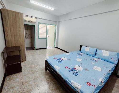 een slaapkamer met een bed met een blauw dekbed bij 辉煌 Icon 民宿 in Bangkok