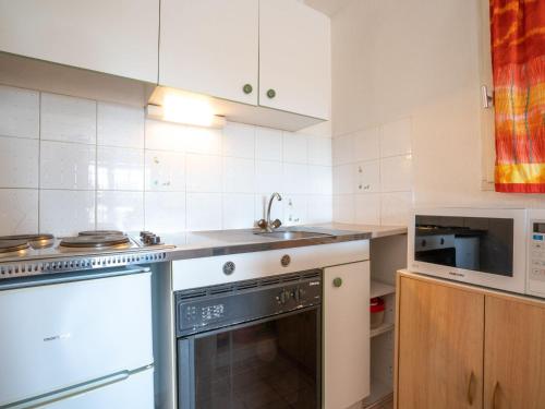 a kitchen with a stove and a sink and a dishwasher at Apartment Le Panama-1 by Interhome in Saint-Aygulf