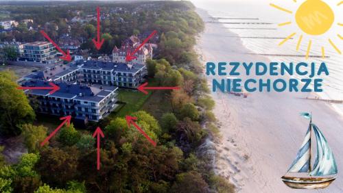an aerial view of a resort with a sailboat on the beach at Nadmorski Loft Rezydencja Niechorze 116 plaża ogród in Niechorze