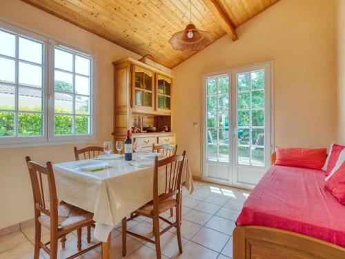 eine Küche und ein Esszimmer mit einem Tisch und einem Bett in der Unterkunft Holiday Home La Bruyère - MVT220 by Interhome in Montalivet-les-Bains