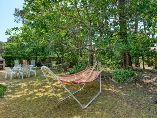 eine Hängematte in einem Garten neben einem Baum in der Unterkunft Holiday Home La Bruyère - MVT220 by Interhome in Montalivet-les-Bains
