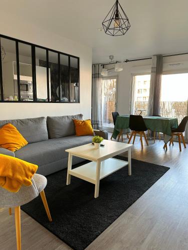 un salon avec un canapé et une table dans l'établissement Havre de paix à 15mn Paris et 15mn Stade de France, à Saint-Denis