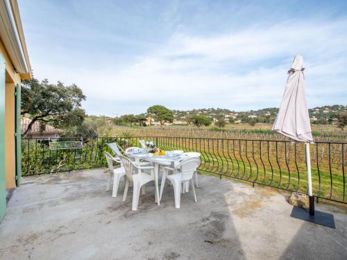 une table blanche avec des chaises blanches et un parasol dans l'établissement Villa Marenco, à La Croix-Valmer