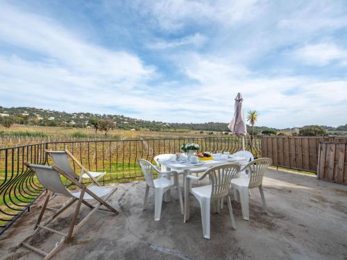 une table blanche et des chaises sur une terrasse dans l'établissement Villa Marenco, à La Croix-Valmer