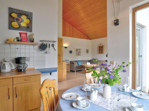 una cocina y comedor con una mesa con flores. en Holiday Home Feriendorf Uslar-1 by Interhome en Uslar