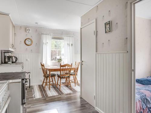 a kitchen and dining room with a table and chairs at Chalet Björkebo by Interhome in Ätran