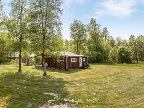 a small red cabin in the middle of a yard at Chalet Björkebo by Interhome in Ätran