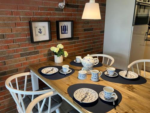 a wooden table with plates and cups on it at Holiday Home Mondmuschel by Interhome in Norddeich