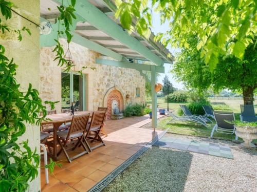un patio al aire libre con mesa de madera y sillas en Holiday Home Babelle - GEM110 by Interhome, en Gaillan-en-Médoc