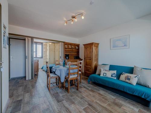 ein Wohnzimmer mit einem blauen Sofa und einem Tisch in der Unterkunft Apartment Martinique 2-3 by Interhome in Le Barcarès