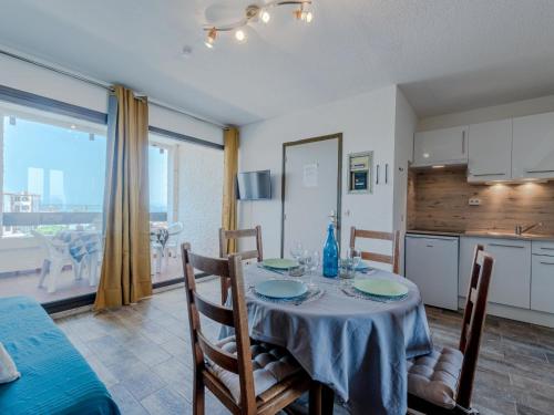 une salle à manger avec une table et des chaises ainsi qu'une cuisine dans l'établissement Apartment Martinique 2-3-1 by Interhome, au Barcarès