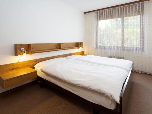 ein Schlafzimmer mit einem großen Bett und einem Fenster in der Unterkunft Apartment Resort al Centro-3 by Interhome in Massagno