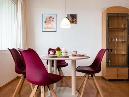 stół z fioletowymi krzesłami w pokoju w obiekcie Apartment G 16 by Interhome w mieście Dittishausen