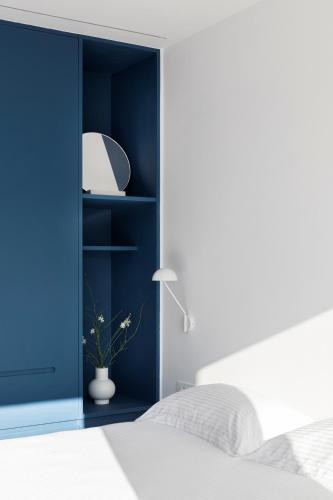 a blue bedroom with a bed and a lamp at Neo Suites in Fira