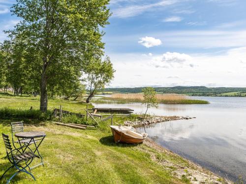 a boat sitting on the shore of a lake at Holiday Home Kaxholmen by Interhome in Huskvarna