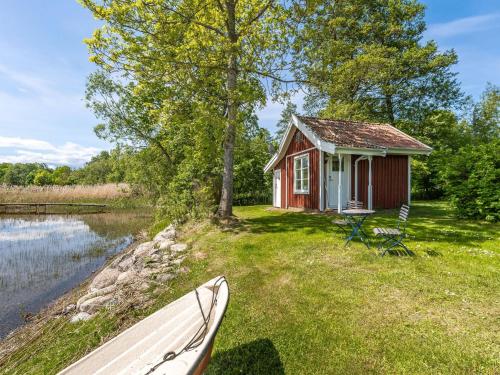a boat parked in front of a small house at Holiday Home Kaxholmen by Interhome in Huskvarna