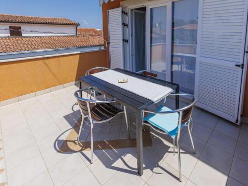 - Balcón con mesa azul y 2 sillas en Apartment Villa Alba-2 by Interhome, en Umag